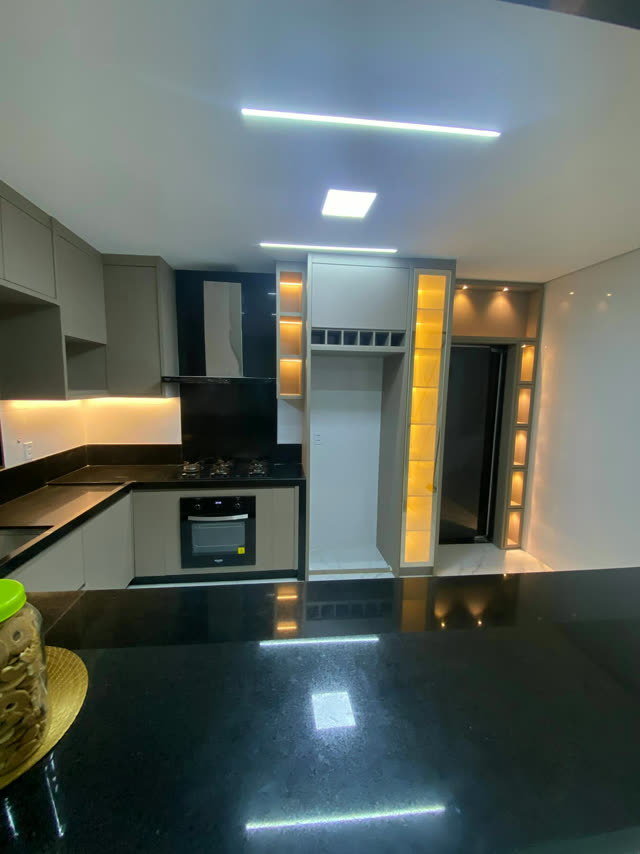 Cozinha planejada escura com nichos e torre iluminados