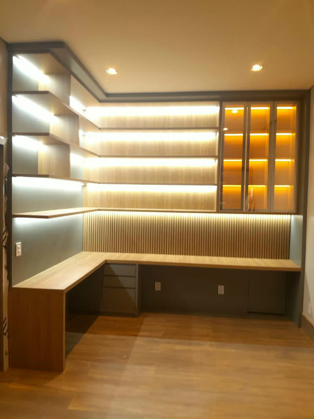 Home office planejado em madeira com prateleiras iluminadas por LED