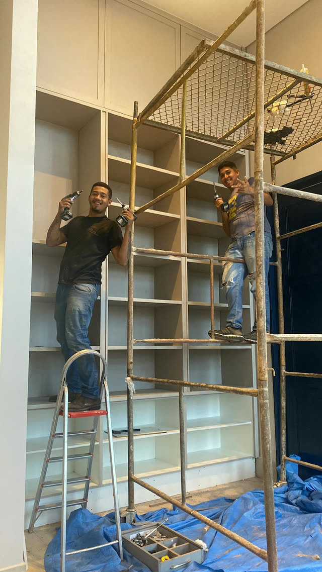 Equipe da EL Móveis montando uma estante planejada