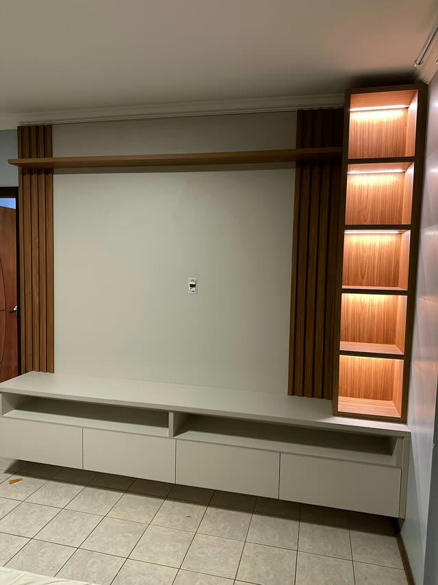 Painel de TV planejado com rack suspenso e estante iluminada
